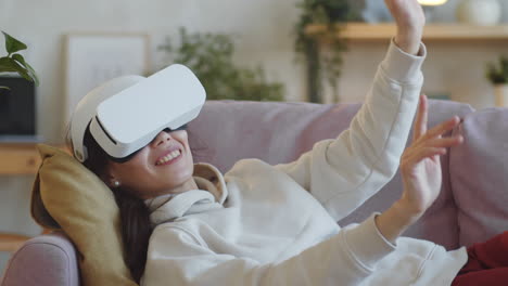 Fröhliche-Frau,-Die-Zu-Hause-Eine-VR-Brille-Benutzt